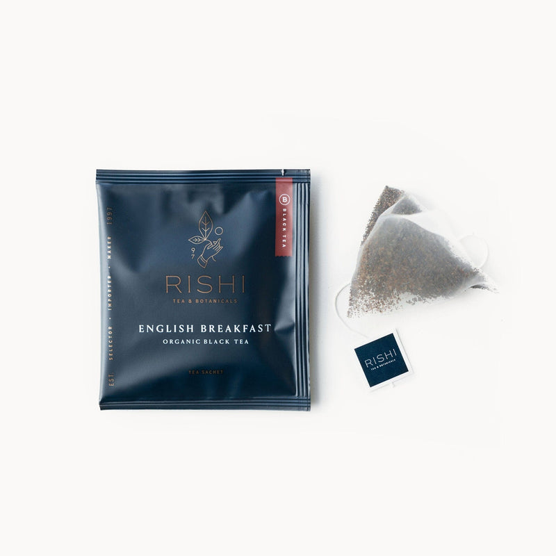 A bag of English Breakfast tea with a Rishi Tea & Botanicals tea bag next to it.