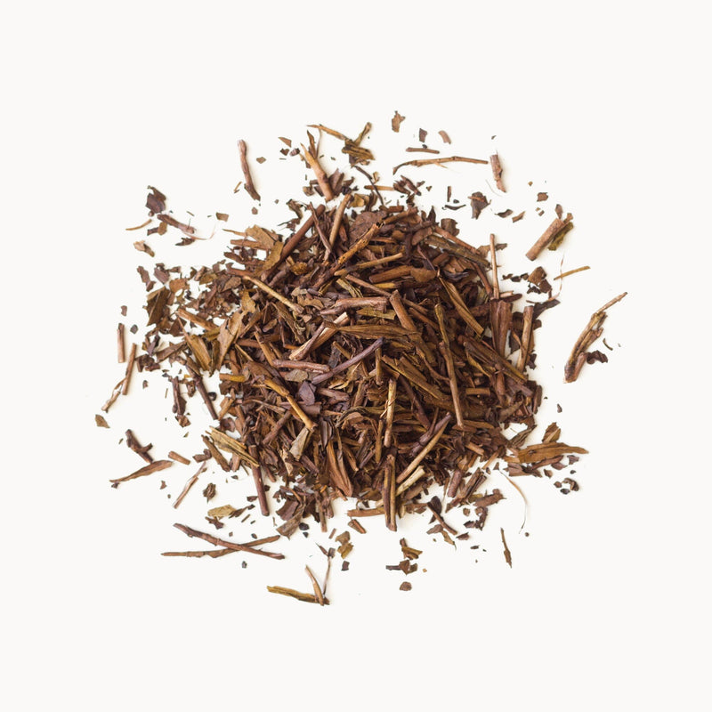 A pile of Rishi Tea & Botanicals Houjicha leaves on a white background.